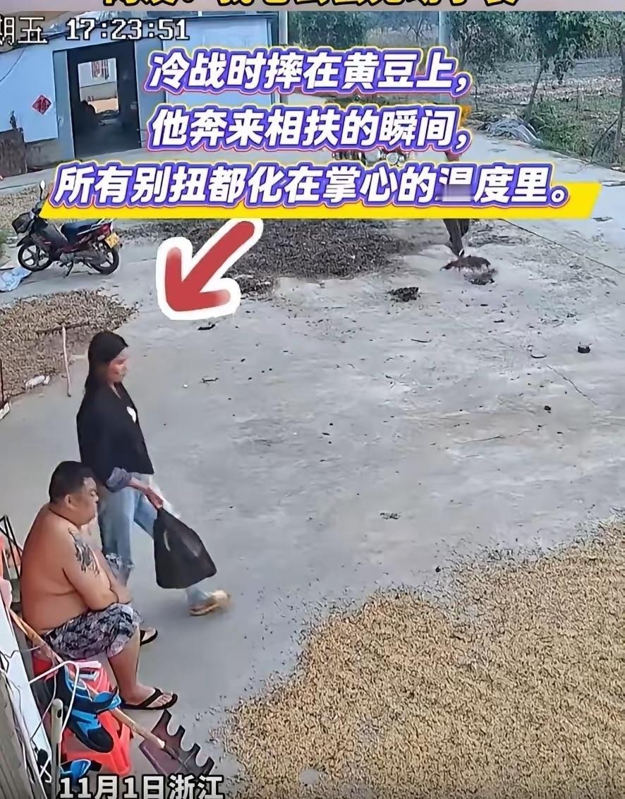 浙江一男子为使黄豆快点晾干，刚刚又耙了一遍。他有点累，坐在凳子上休息。妻子提着