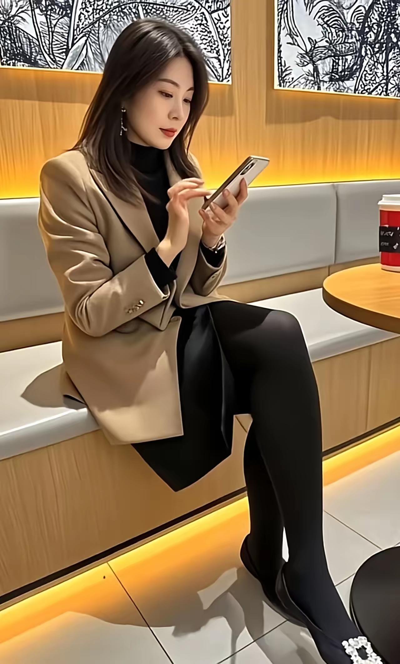 都市白领的优雅时刻，沉浸在手机的魅力中。