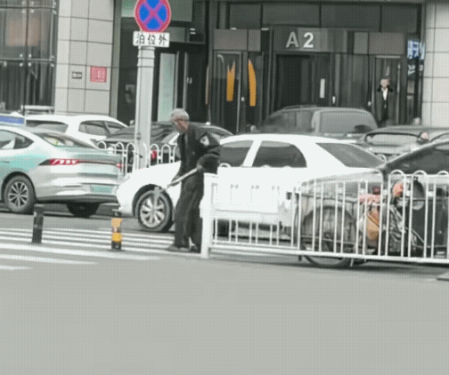 说出来你可能不信，就在大白天，马路上，一个老大爷拎着铁锤，哐哐几下把路边的路障给