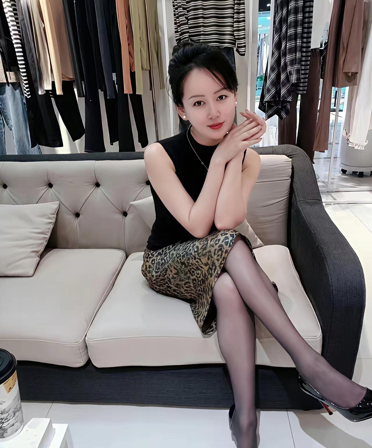 穿豹纹裙子的女人坐在沙发上。