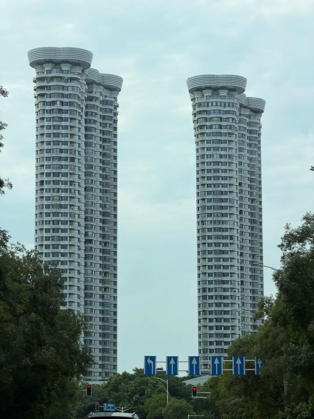 南京这几栋楼顶着圆盘一样的帽檐，造型确实别致。据说设计灵感源自祥云，那向外舒展、