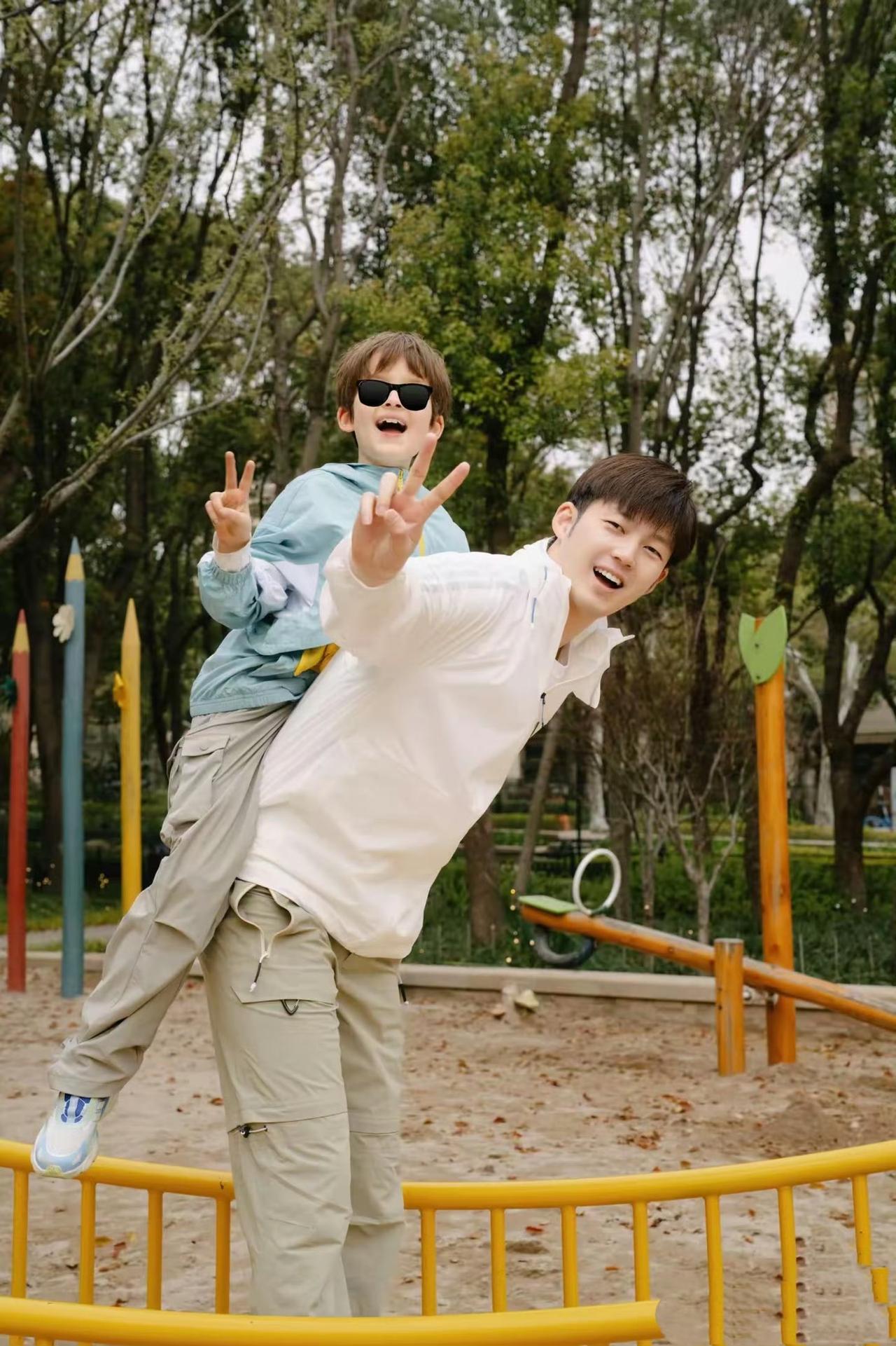 董力携儿子一同漫步公园，两人身着清爽帅气的亲子装，画面温馨有爱。年仅8岁的尤利斯