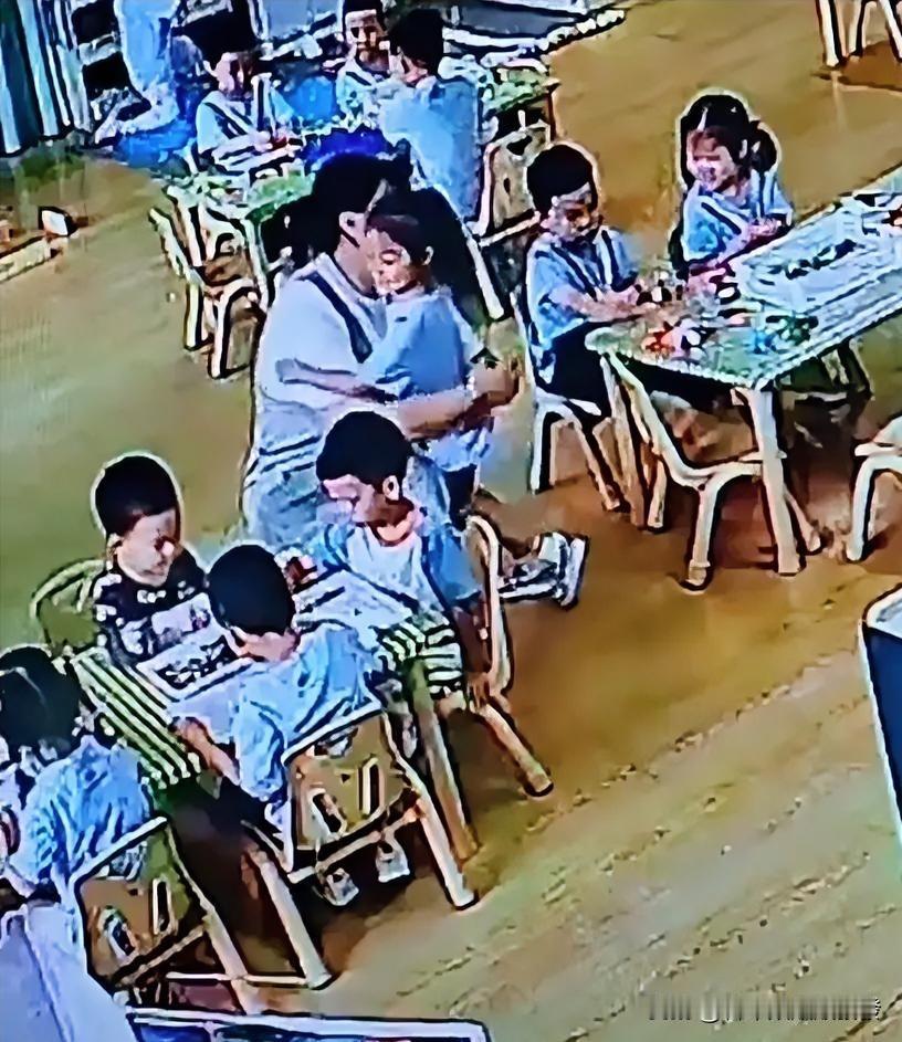 幼儿园内，一位怀孕的老师正弯腰辅导一名男生做手工，邻桌的女生看到后，悄悄从自己座