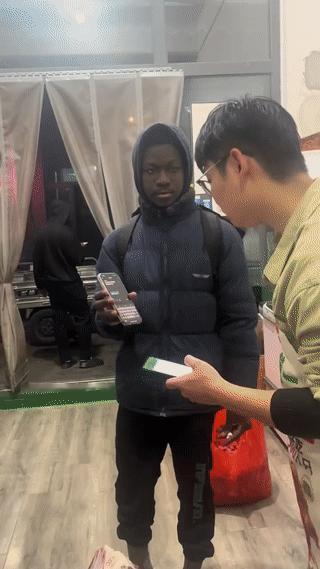 两名黑人男子来到菜市场的一家肉铺里买肉。他们最后买很多肉,付款的的时候还特别的