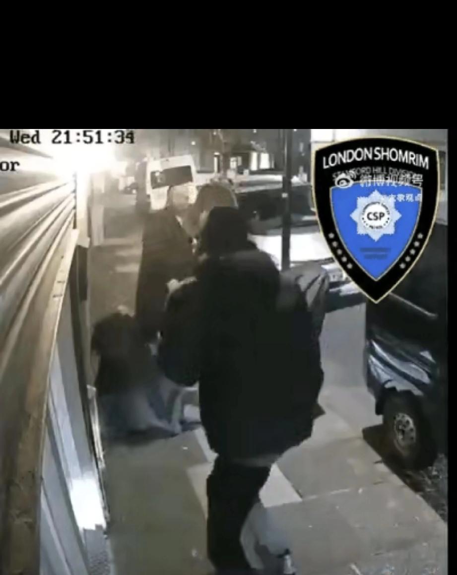 当地时间4月15日21点，英国伦敦，2名犹太拉比在街头卷帘门前，1人在打电话，