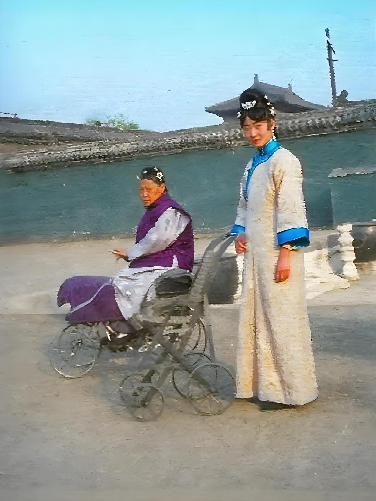 照片里，紫禁城中，婉容身着传统长袍，头上戴着精致的头饰，正摆弄着一个小车，这小车