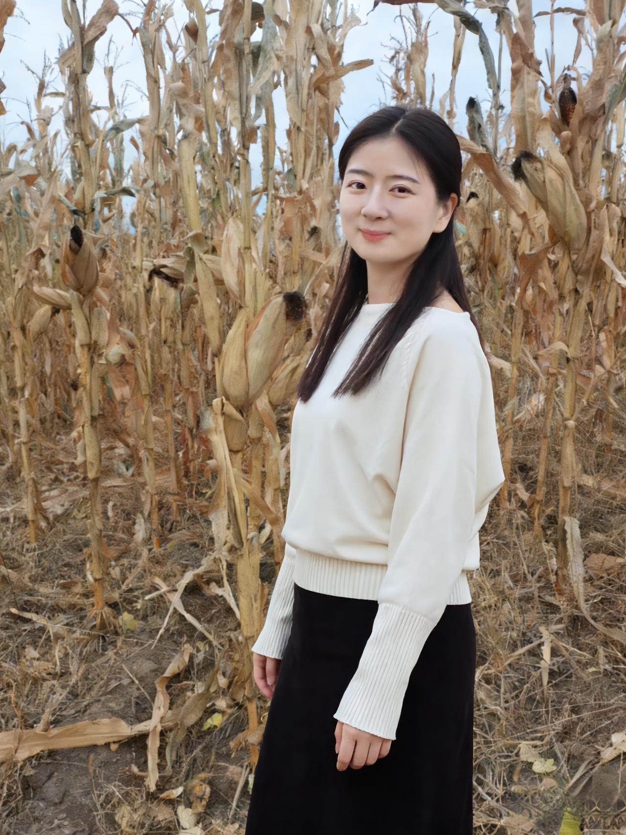 白衫黑裙立秋荒，玉米杆枯映晓霜。一笑嫣然寒色里，恍如梅萼绽芬芳。