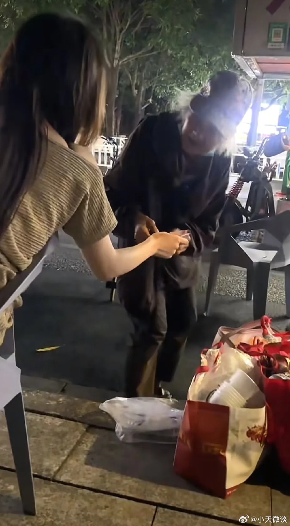夜色中，广西一条街边摆满夜宵摊，吃夜宵的人多了起来。一位白发老奶奶在摊位周围走来走去，捡客人丢下的空