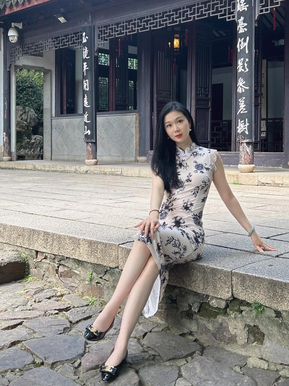 古典园林中的优雅时光，旗袍与石阶的完美融合。