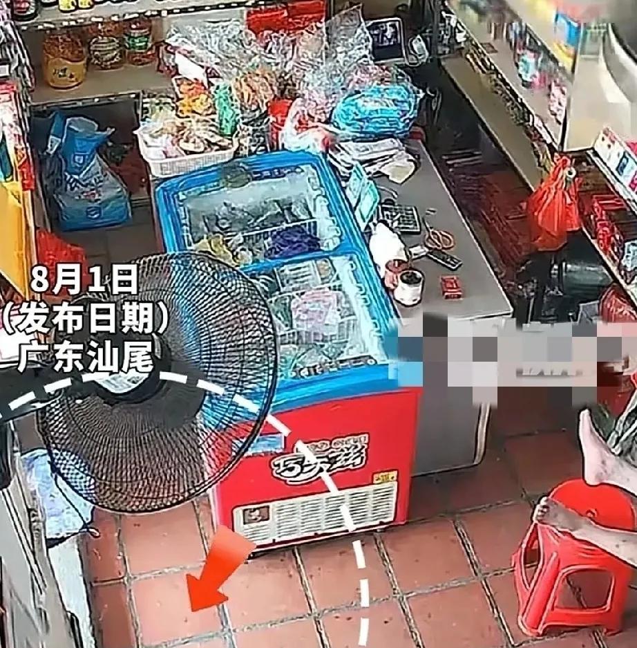 7月31日，广东汕尾的一家商铺。天气炎热，男子光着膀子，吹着电风扇，脚搭在塑料凳