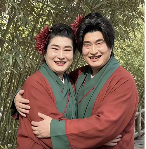 大衣哥朱之文跟开封王婆长得太像了，穿上相同的衣服，像极了双胞胎。