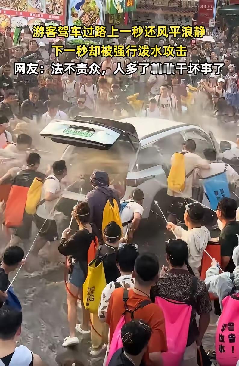 这样的泼水节已经变味了！云南泼水节，一辆辽A的白色新能源车路过，前一秒大家还只是