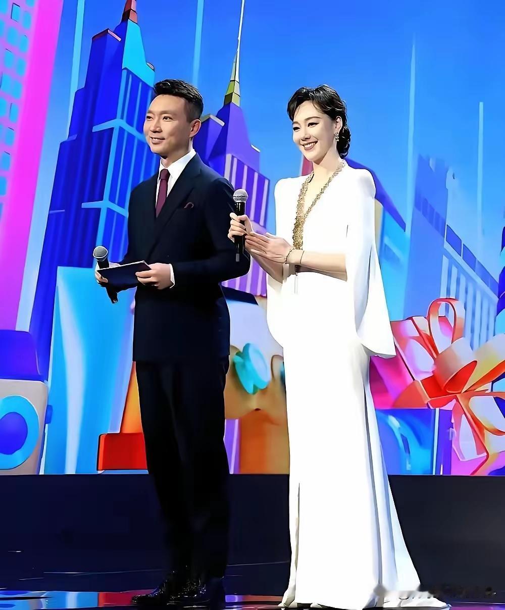 站在康辉身旁的这位女主持人，你认出来了吗？一袭白裙优雅亮相，举手投足落落大方。