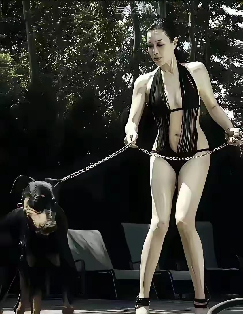 钟丽缇身着黑色设计感极强的挂脖式连体泳衣，采用深V与镂空设计，搭配黑色高跟凉鞋，