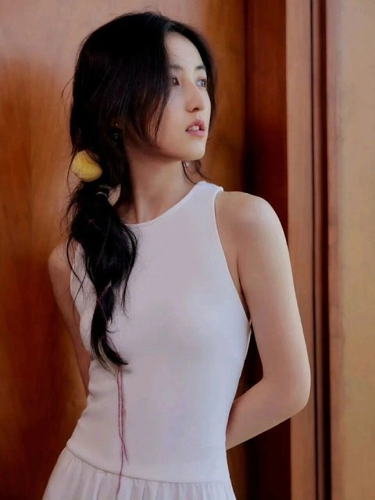 张子枫用影子抚摸小o张子枫蹲在光影里，指尖轻拢的弧度顺着小o柔软的毛发轮廓滑落，