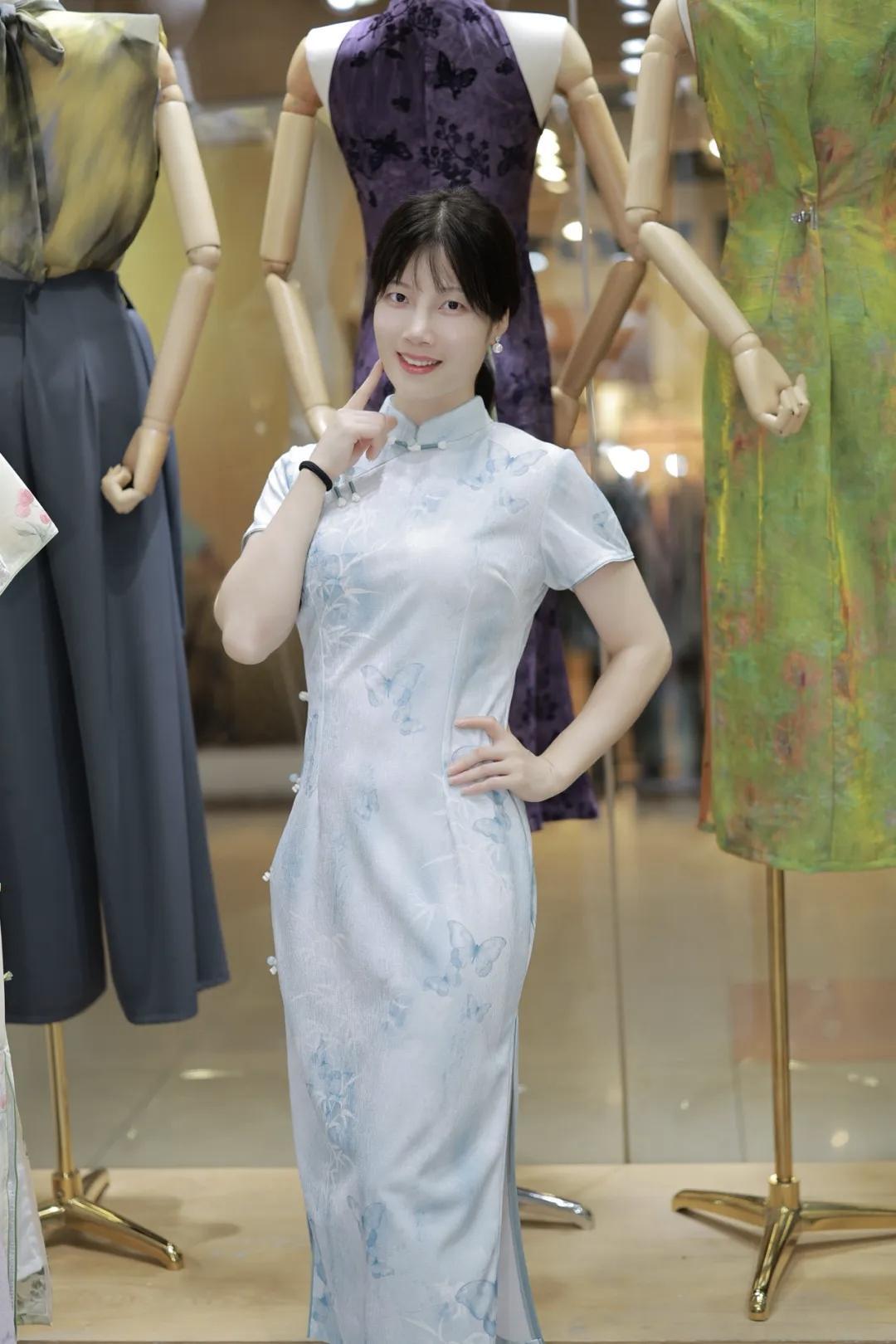 穿旗袍的姑娘在店里摆姿势。