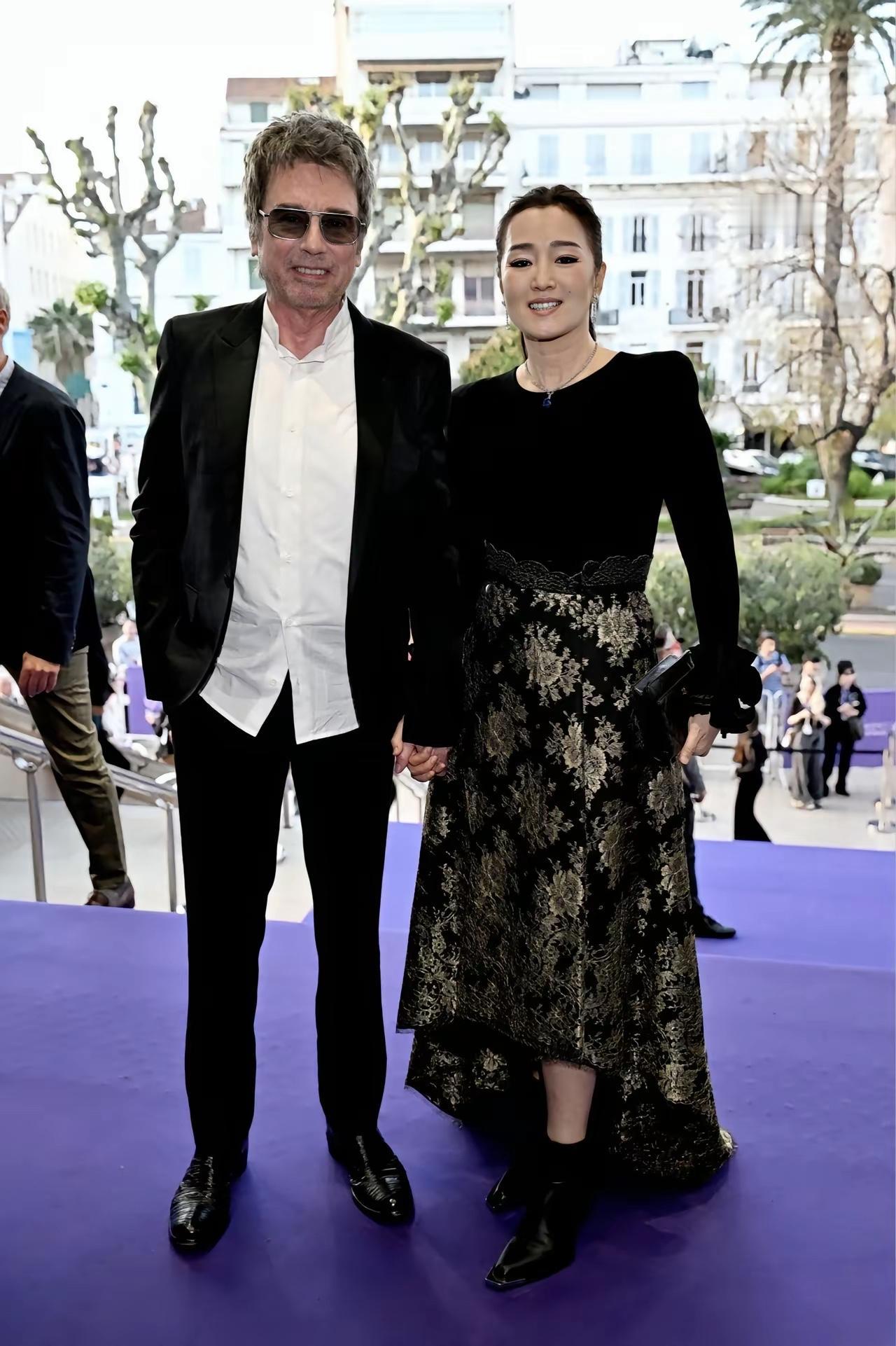 近日，巩俐与法籍老公雅尔手牵手的画面，夫妻俩十分恩爱。61岁巩俐依然有着“女