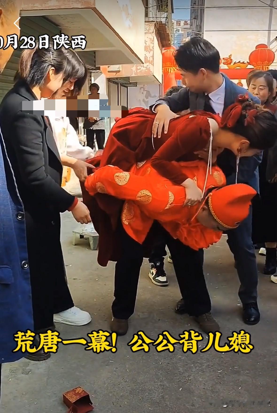 陕西一对新人结婚，习俗是让公公背着儿媳妇进门。儿媳妇在公公背上手捂着胸，一脸痛