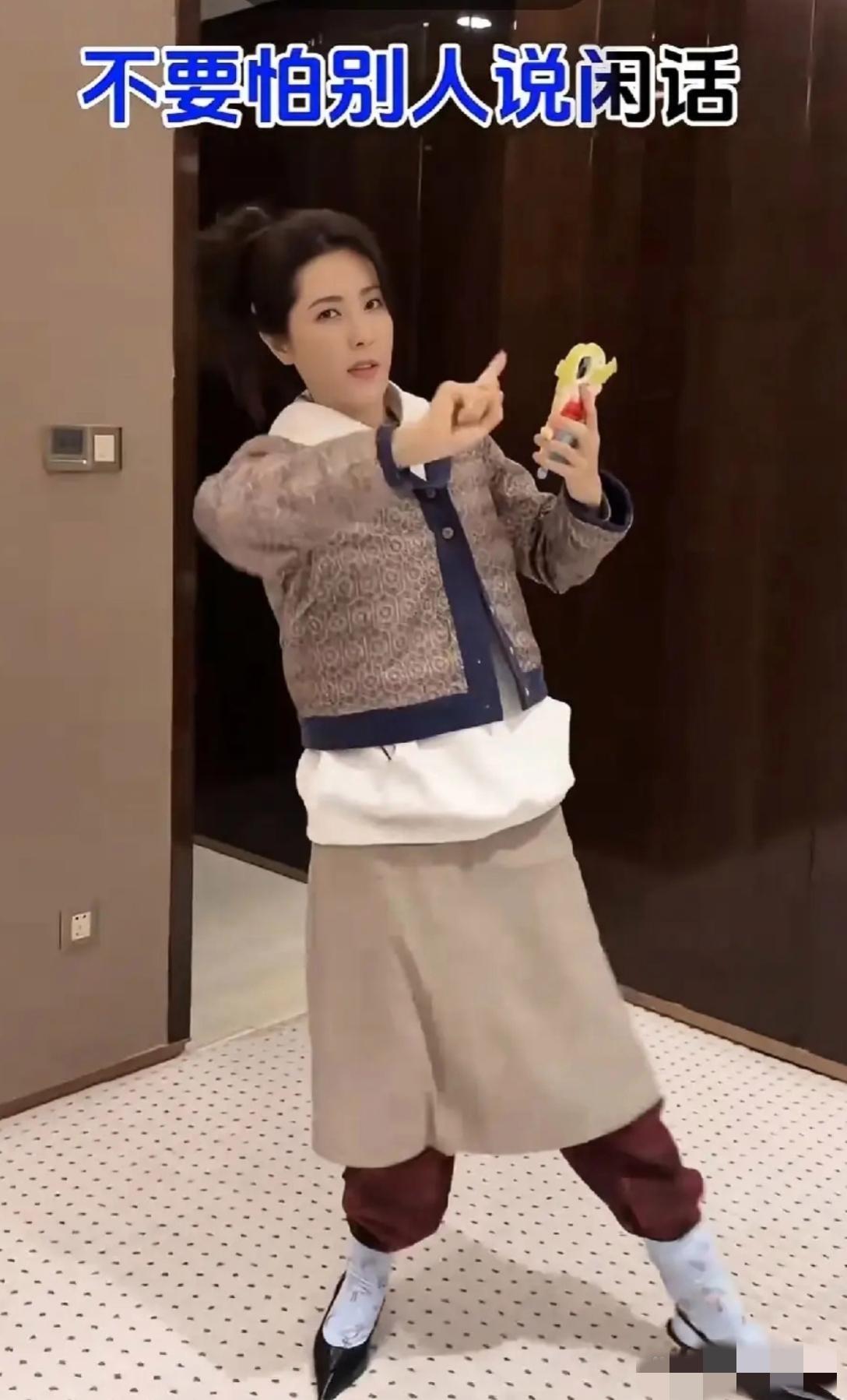 天呐，黎姿的衣着打扮太不敢恭维了：浅色裙子里还穿着酒红色的裤子，长款白衣外还套着