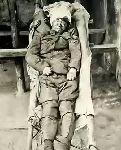 1938年，台儿庄战场，随军记者按下了快门。画面里，一个将军躺在担架上，头缠