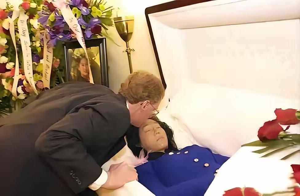 这是张纯如最后的遗容，她安详地躺在棺椁里，丈夫亲吻她的额头，与她做最后的告别，她