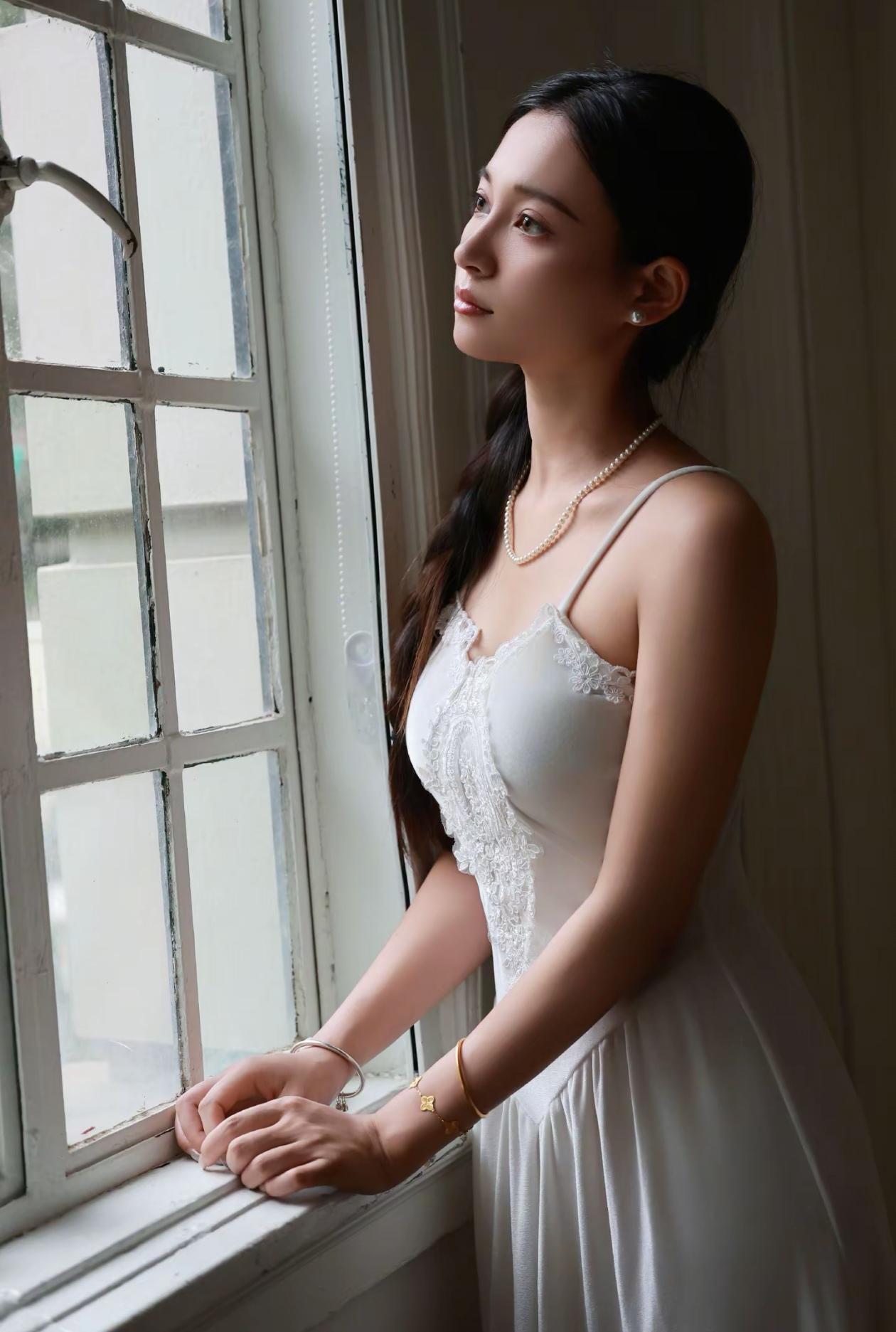 窗边沉思的美丽新娘，温柔的光线洒在她洁白的婚纱上，仿佛时间在这一刻静止。