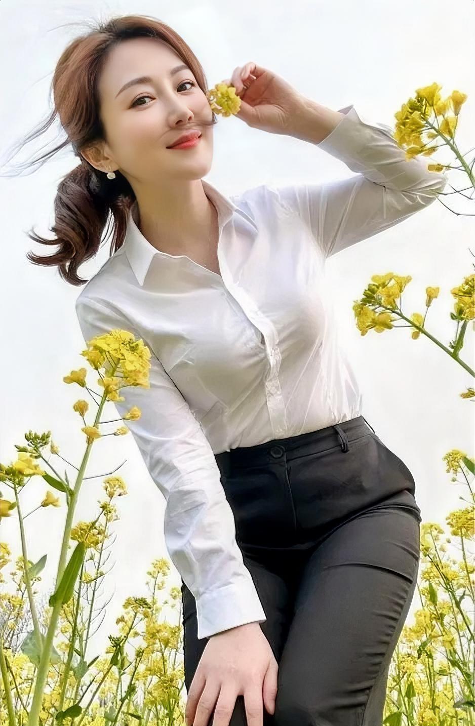 春风拂面，花海金黄，白衫黑裤，自在清爽。手执繁花，笑意流淌，微风轻扬