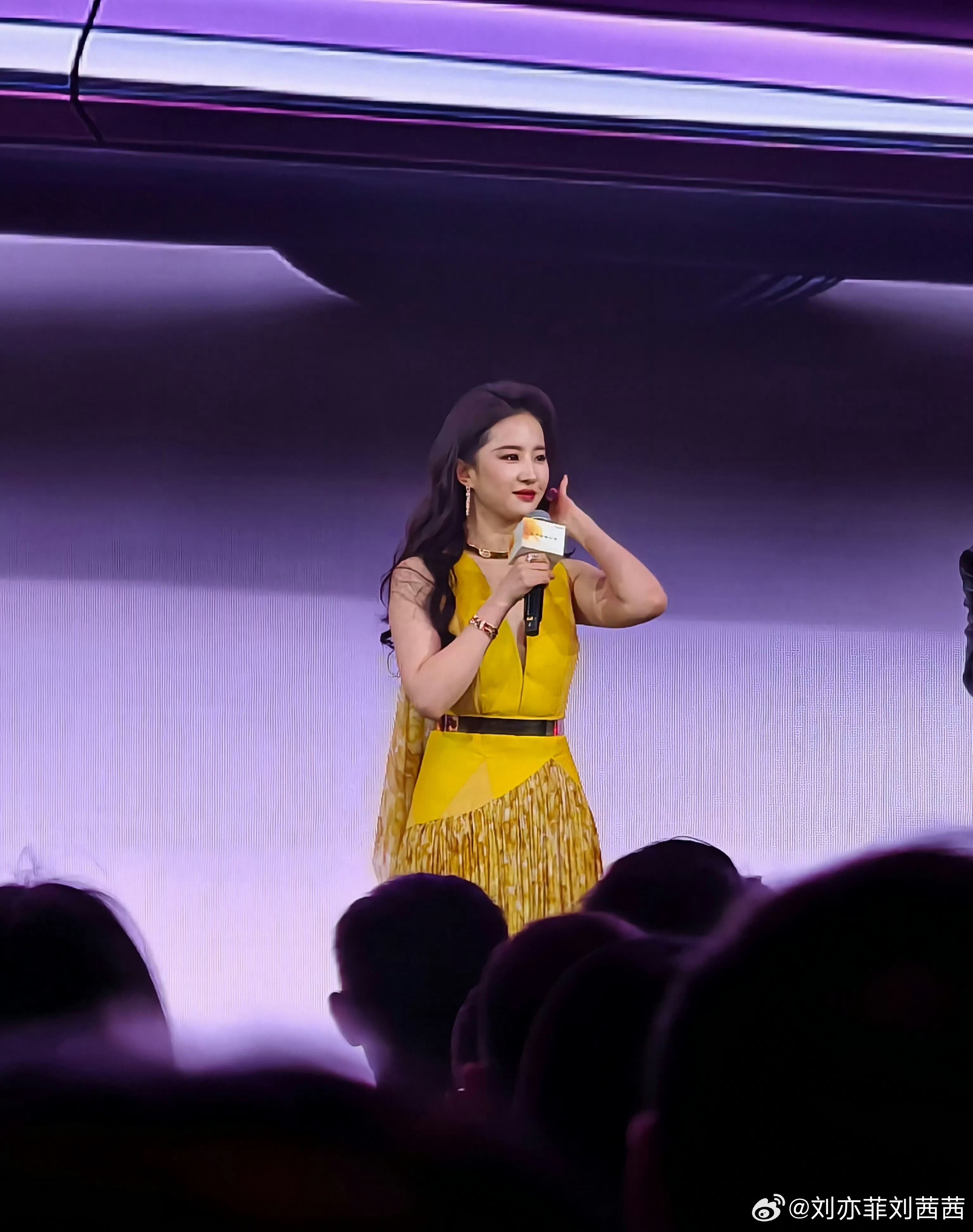 刘亦菲这套造型以高饱和亮色为核心，明黄色深V挂脖礼服勾勒出优越肩颈线条，挂脖设计