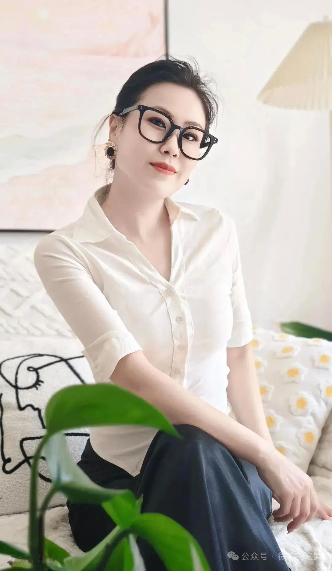 一个戴眼镜的女士坐在沙发上。