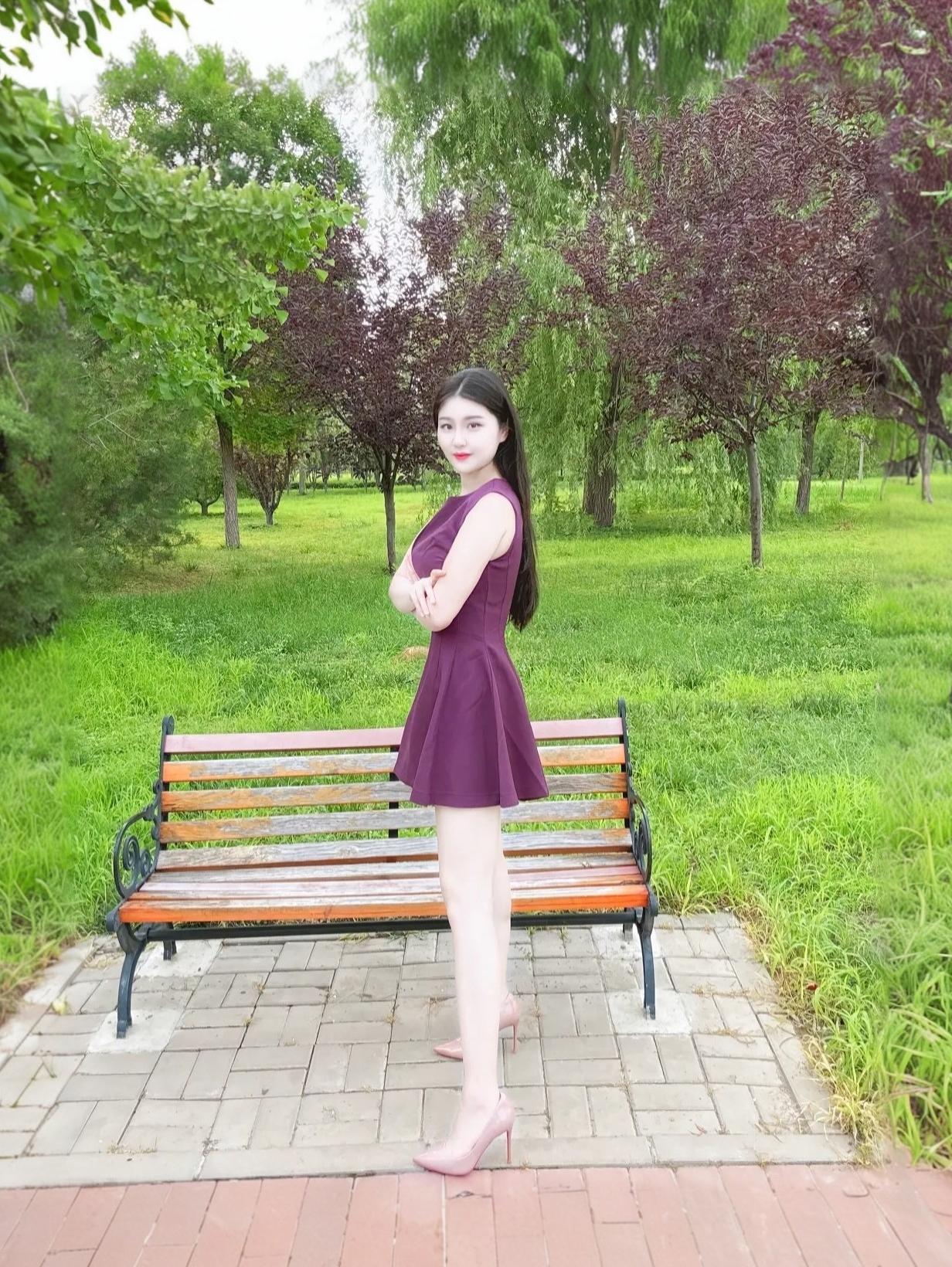 优雅紫裙少女，静坐公园长椅，绿意盎然，尽享宁静时光。