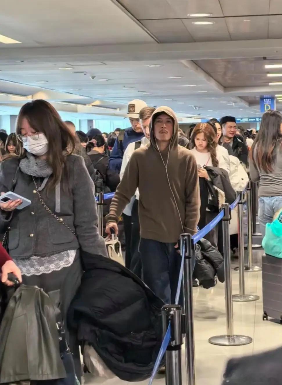 陈冠希在日本机场被偶遇，他穿着驼色卫衣和牛仔裤，留着八字胡，身材消瘦，他整个人好