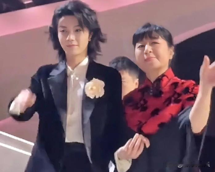 华晨宇殷秀梅：乐坛跨代情，温暖共传承华晨宇与殷秀梅手挽手下班的画面，如冬日暖