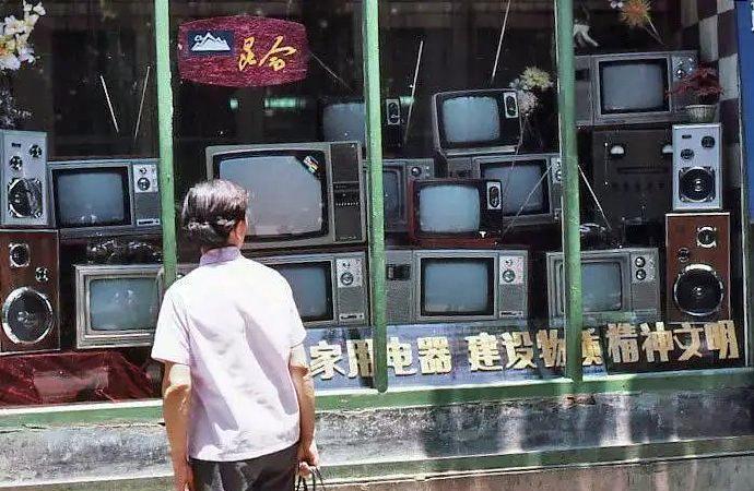 1983年，昆明，一名女子站在家用电器商店的橱窗前久久不愿离去。橱窗里面摆放着不