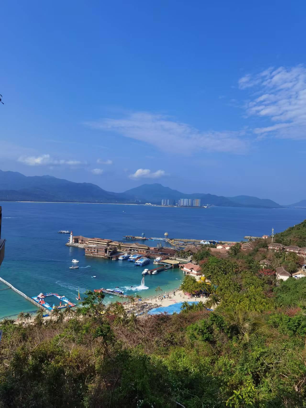 站在高处俯瞰这片海，蓝得像被上帝打翻的调色盘。远处的山影在雾里若隐若现，近处的浪