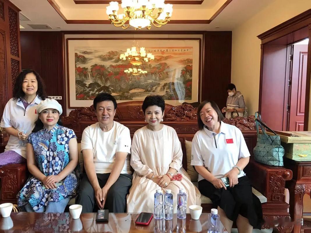 董文华、张也、吕继宏等人在中式风格室内合影，背景有山水画作与雕花木门，氛围庄重典