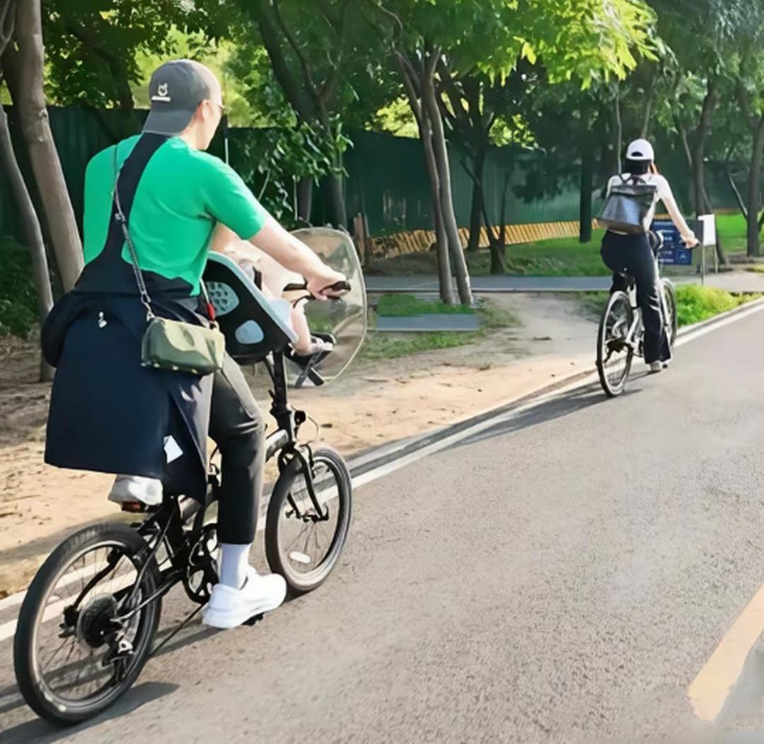 陈伟霆、何慧夫妇带着十个月宝宝在北京东坝骑单车出行，夫妻俩都背着一个大背篼，陈伟