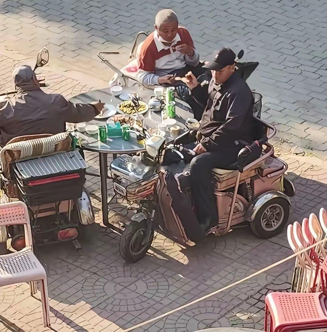 街头三位残疾老伙计坐轮椅相聚畅饮言欢​​​