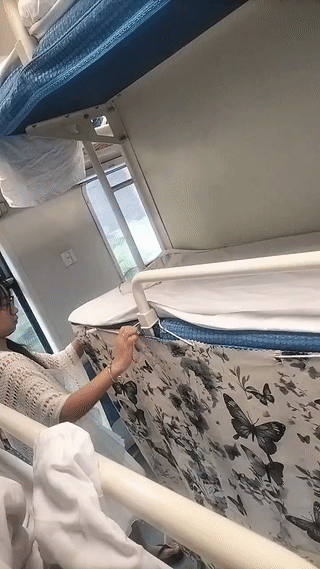 这个女孩乘坐火车卧铺。真的非常注意保护自己的隐私。她还专门带了围帘把自己的下铺