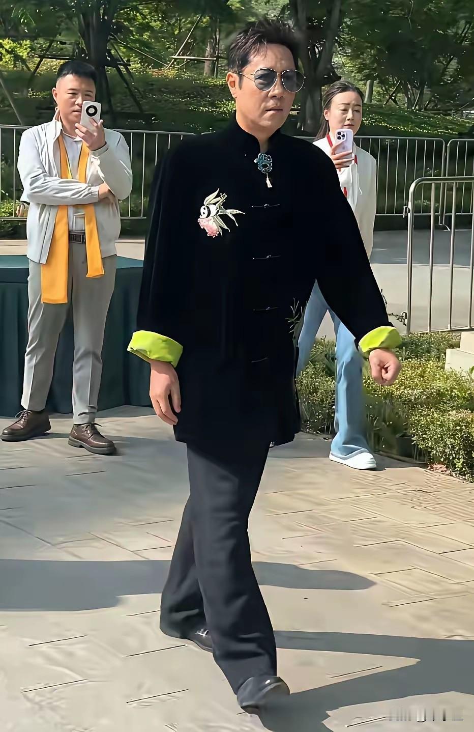 蔡国庆穿衣服的确另类，不是花的，就是绿的，这不又穿上老太太的服装，引起游客拍照观