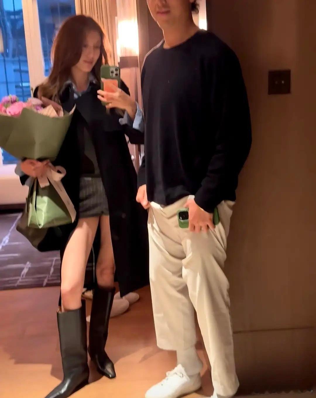 吴千语晒节日照，怀里抱着鲜花和老公合影，两人用情侣手机壳好甜，施伯雄看着她笑得一