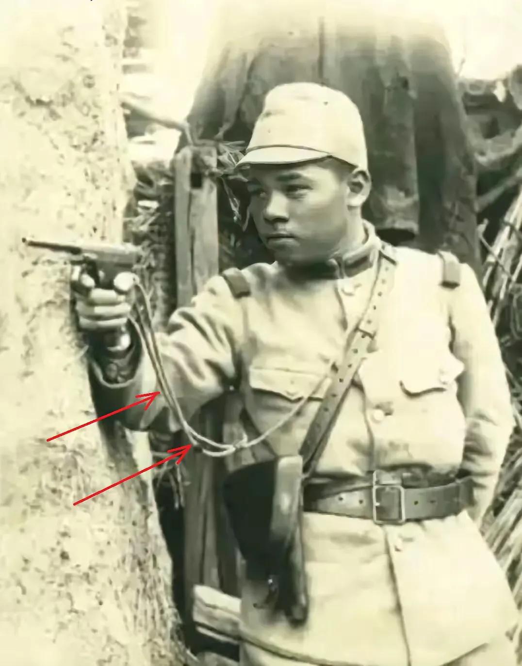 一名日军士兵用手枪正在瞄准中国人射击。他所使用的手枪是南部十四式手枪，该枪配有一