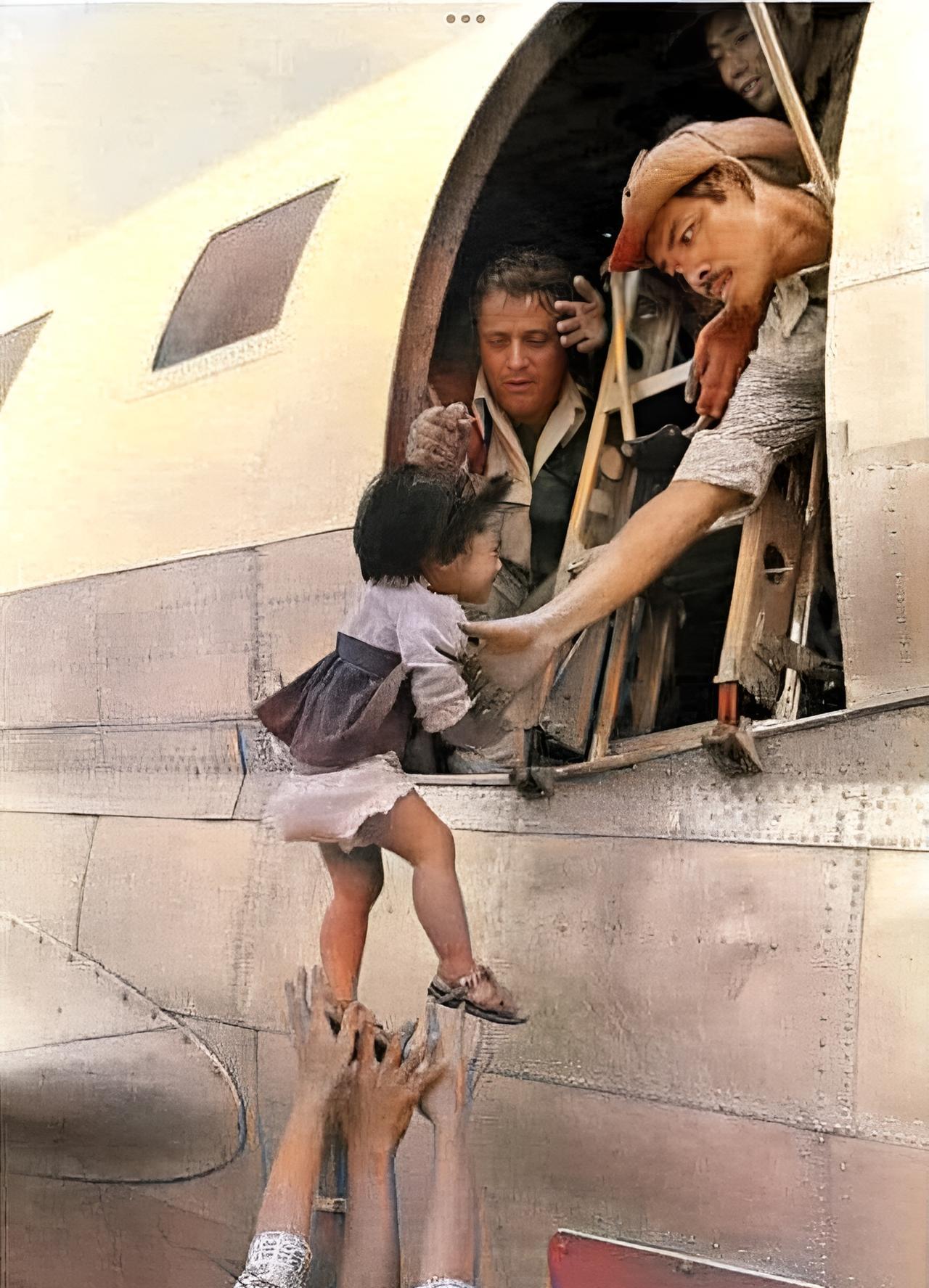 这是1975年4月29日，一位越南母亲高高举起自己的双臂将女儿抛给在越南西贡市郊