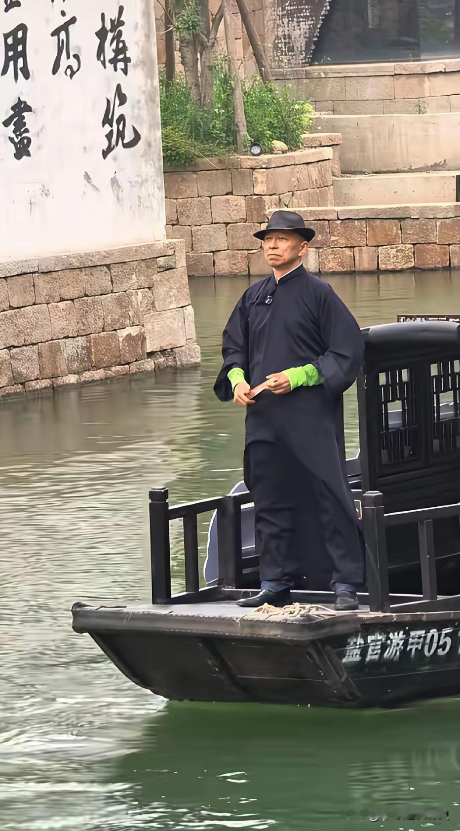 张朝阳身着长衫，头戴礼帽立于船头，试图佯装成地方党员前去接头。他亮出绿袖暗号，