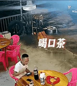 反应机敏。男子在路边摊吃东西，边喝茶边等待上菜。男子悠闲的喝一口茶，把杯子放下