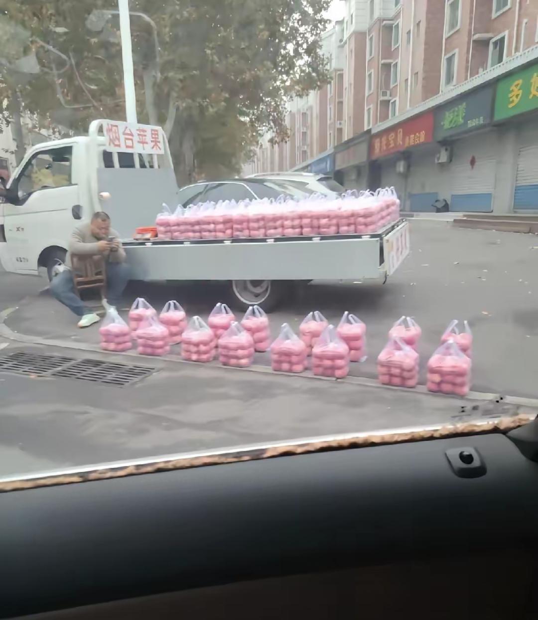 卖苹果的大哥有点不一样摊上的苹果列队似的，横竖成线。他不吆喝，价格也不低，路
