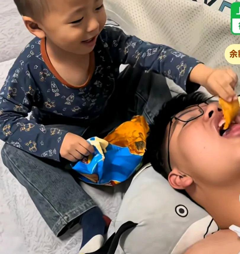 弟弟殷勤的给哥哥喂零食，妈妈说你干啥对你哥这么好，弟弟说我一直让哥哥吃撑死他妈