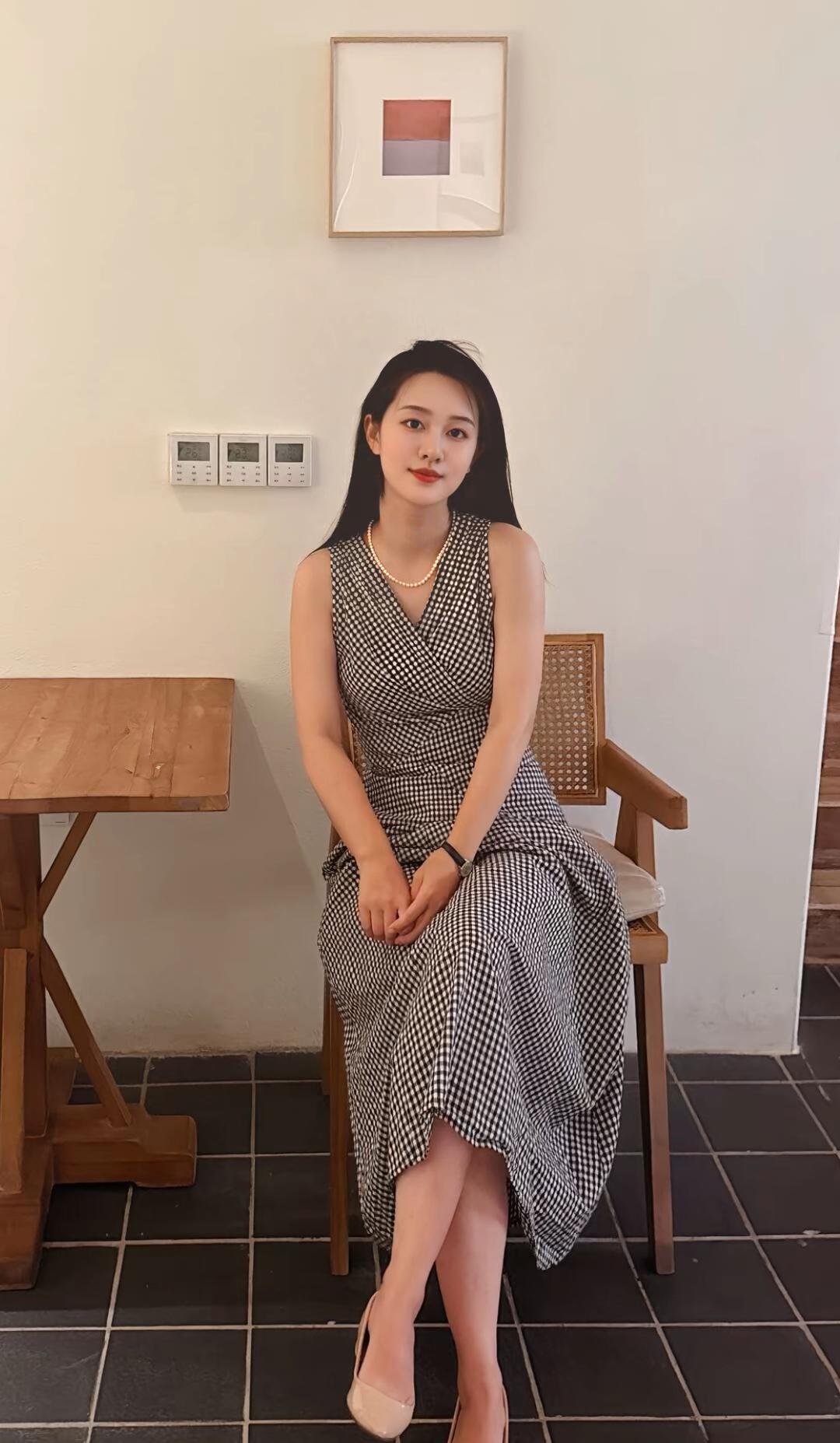 优雅坐椅间，黑白格裙映画框。