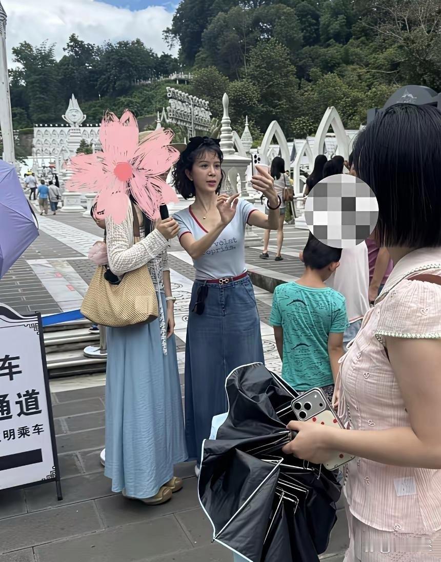 51岁金巧巧带孩子现身云南旅游被偶遇，她的打扮时尚，全身名牌加持，妥妥的豪门精致