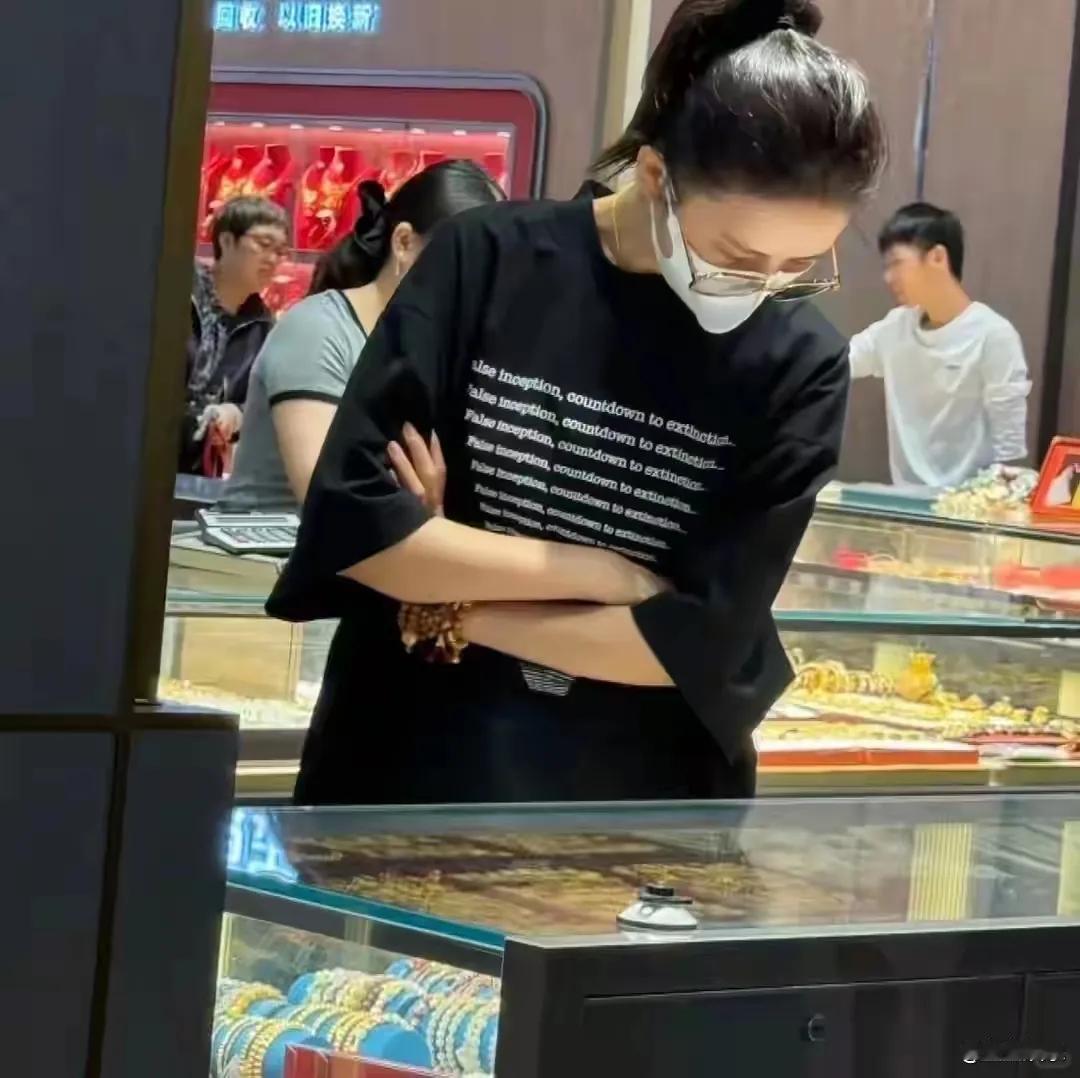 佟丽娅近日现身深圳水贝黄金市场，素颜扎高马尾选购黄金，稀疏发际线与假发包引发关注