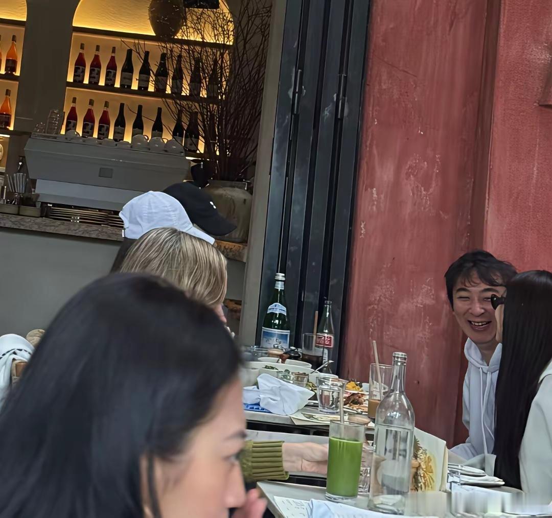 王思聪在美国餐厅用餐时的一幕，身边坐着几位美女，有说有笑，他看起来非常快乐。​